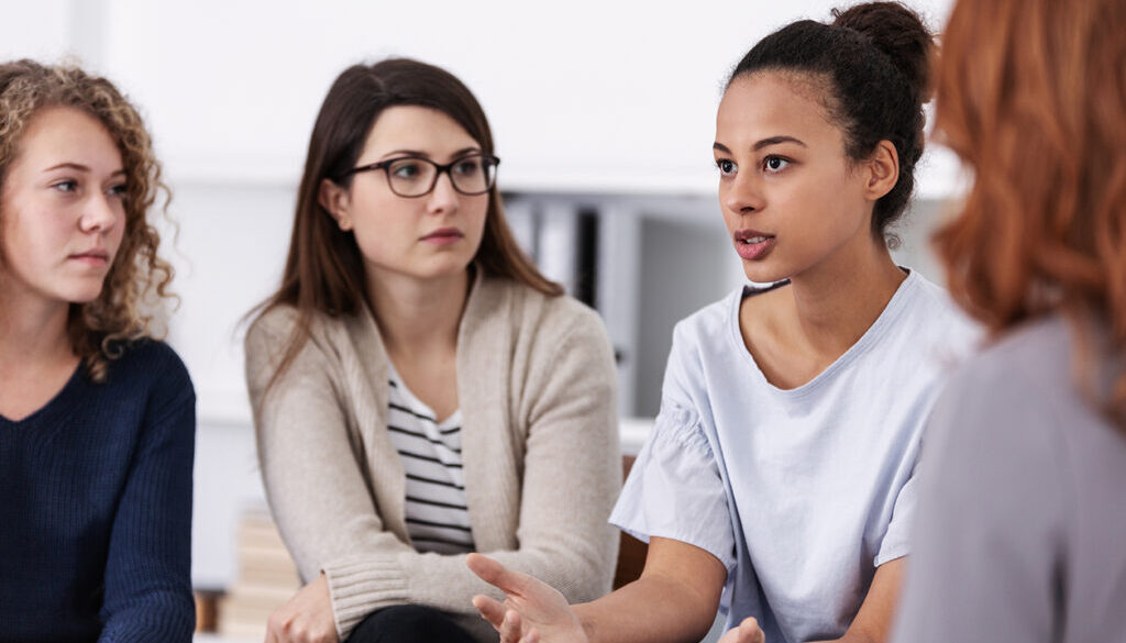 women supporting each other during psychotherapy group meeting